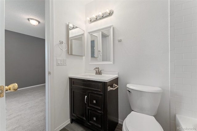 bathroom featuring toilet, vanity, and a textured ceiling