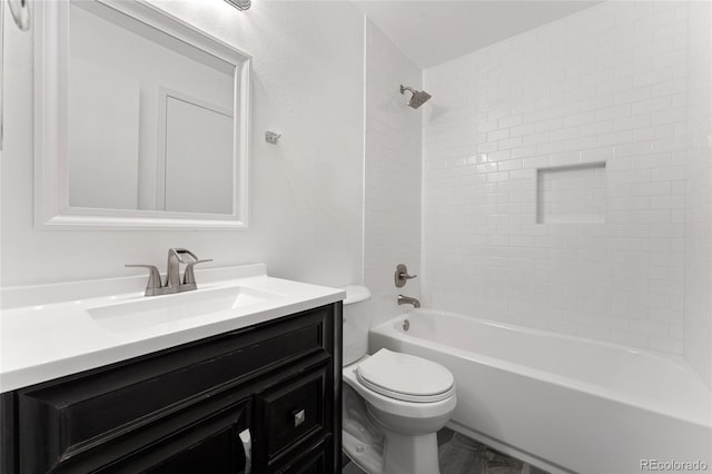 full bathroom featuring toilet, vanity, and tiled shower / bath