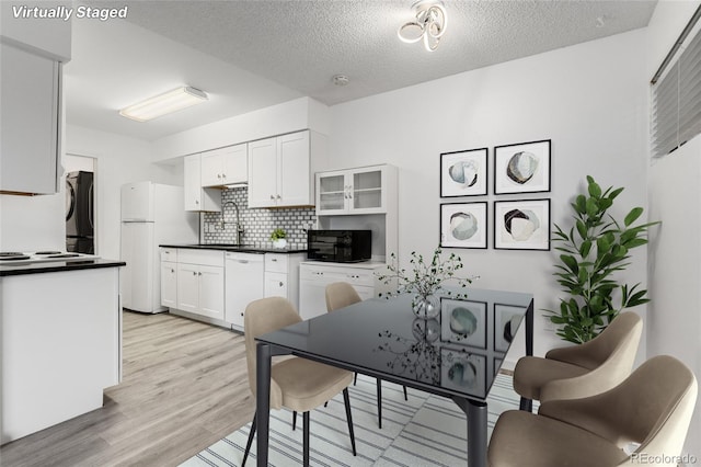 kitchen with tasteful backsplash, sink, white appliances, white cabinetry, and a textured ceiling