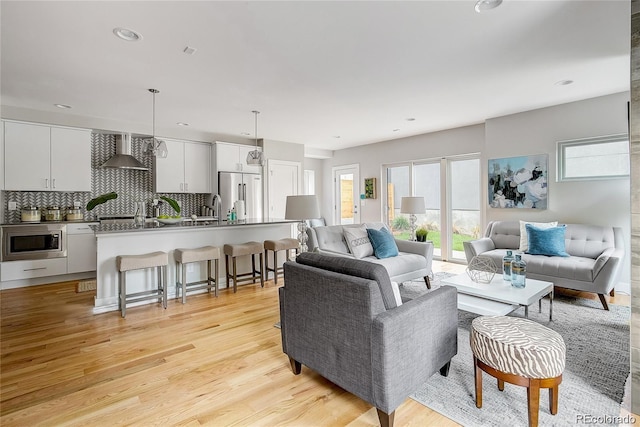 living room with sink and light hardwood / wood-style floors