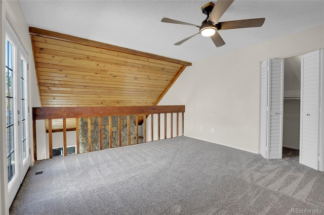 interior space featuring vaulted ceiling, ceiling fan, carpet floors, and a textured ceiling