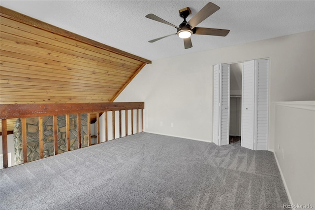 bonus room featuring vaulted ceiling, carpet flooring, and a textured ceiling