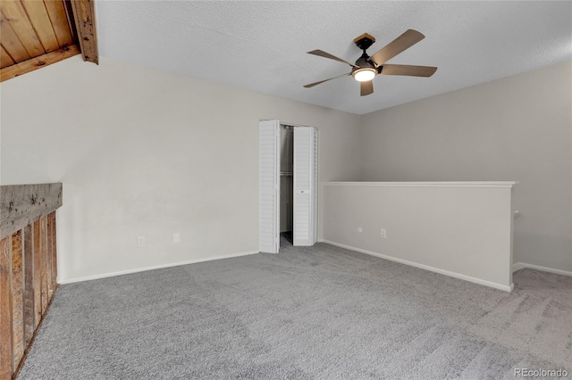 interior space featuring vaulted ceiling with beams, ceiling fan, a textured ceiling, and carpet