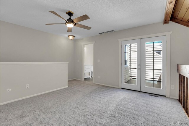 unfurnished room featuring french doors, light colored carpet, ceiling fan, and a textured ceiling