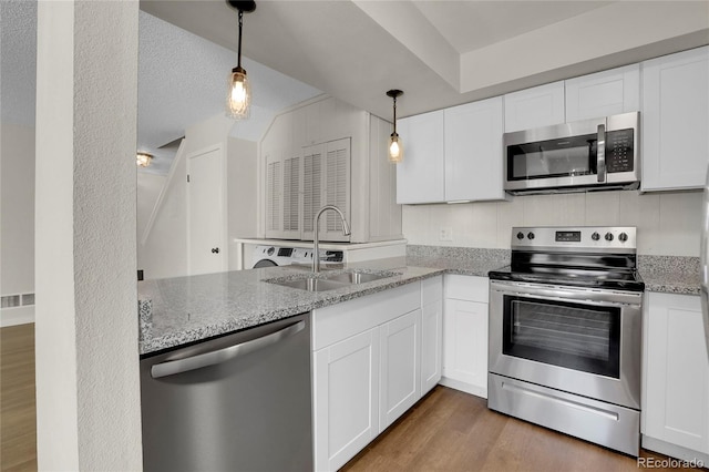 kitchen with white cabinetry, stainless steel appliances, and light stone countertops