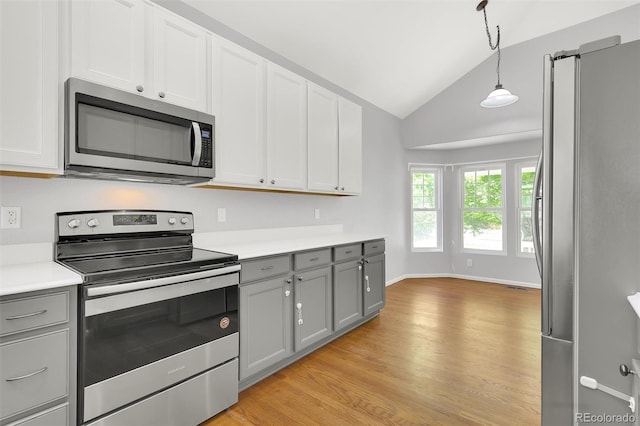 20394 E Colgate Pl, Aurora, CO 80013 - kitchen with stainless steel appliances, gray cabinetry, vaulted ceiling, light countertops, and light wood finished floors