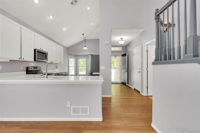 20394 E Colgate Pl, Aurora, CO 80013 - kitchen featuring stainless steel appliances, white cabinetry, light wood-style flooring, recessed lighting, and a peninsula