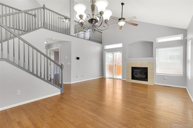 20394 E Colgate Pl, Aurora, CO 80013 - unfurnished living room featuring high vaulted ceiling, stairway, baseboards, wood finished floors, and a chandelier