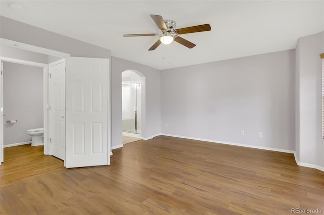 20394 E Colgate Pl, Aurora, CO 80013 - empty room with arched walkways, ceiling fan, baseboards, and wood finished floors