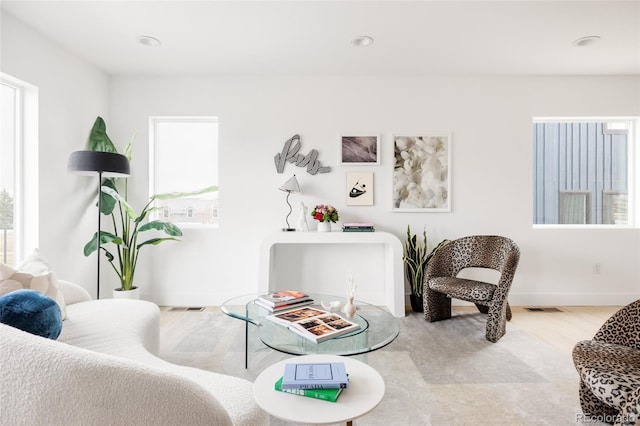 living area featuring visible vents, plenty of natural light, and baseboards