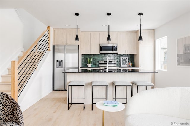 kitchen with appliances with stainless steel finishes, pendant lighting, and a kitchen island