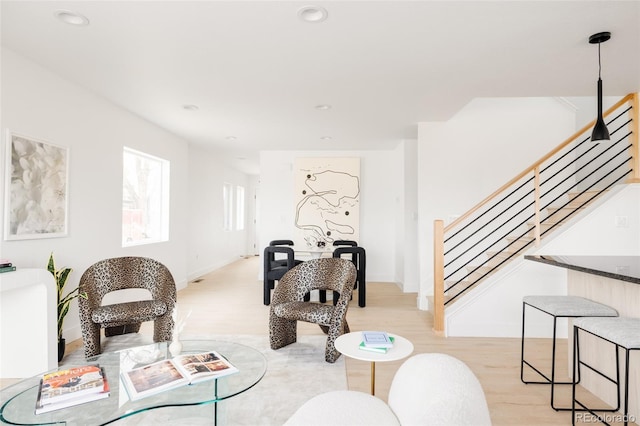 living area with stairs, baseboards, light wood-style flooring, and recessed lighting