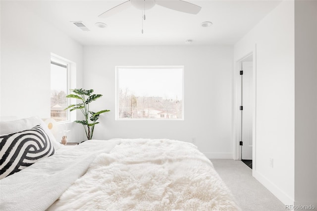 carpeted bedroom featuring baseboards, visible vents, and ceiling fan