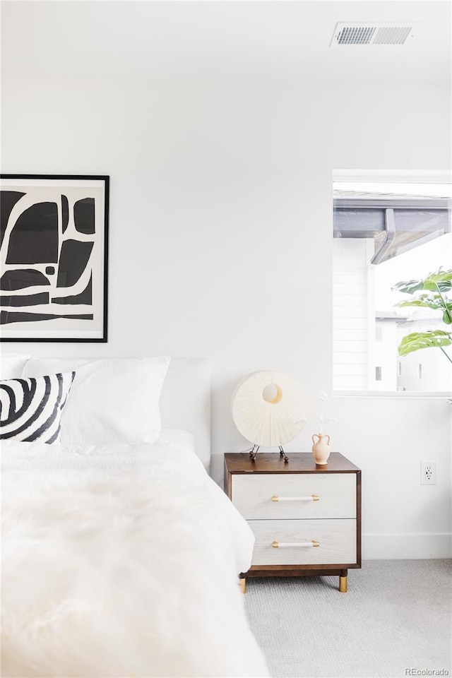 carpeted bedroom featuring baseboards and visible vents