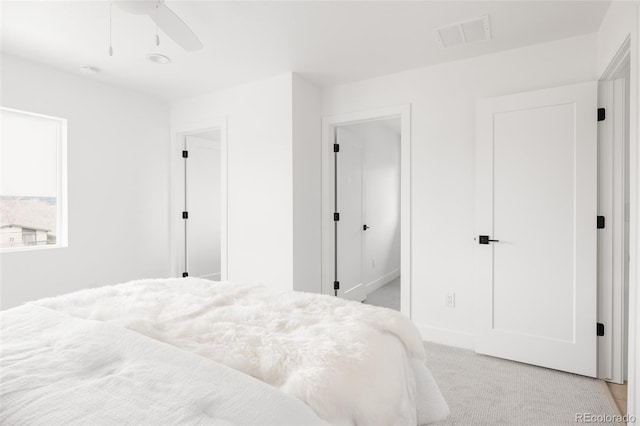 bedroom with visible vents, a ceiling fan, and light colored carpet