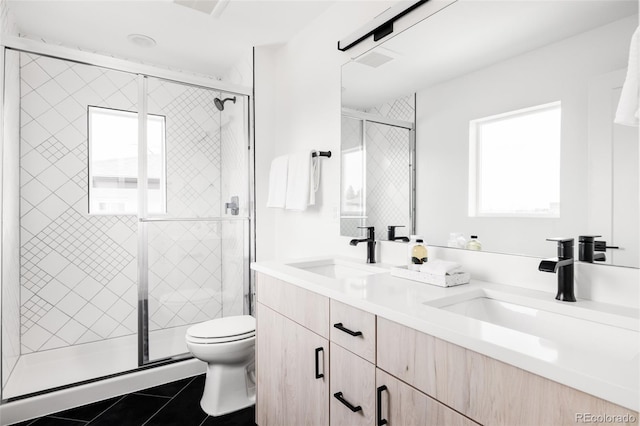 bathroom featuring double vanity, toilet, a sink, and tile patterned floors