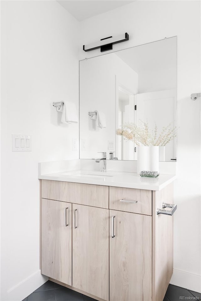 bathroom featuring vanity, baseboards, and tile patterned floors