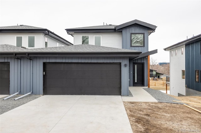 view of front of home with board and batten siding, roof with shingles, driveway, and a garage