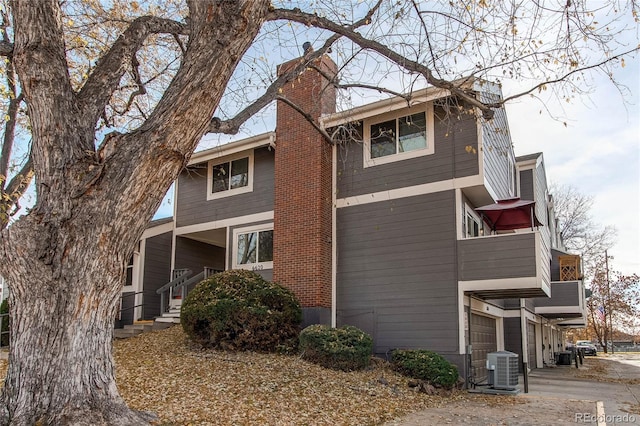 view of side of property featuring a garage and central air condition unit