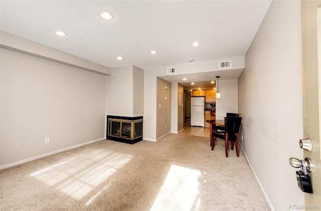 living room featuring a multi sided fireplace and light colored carpet