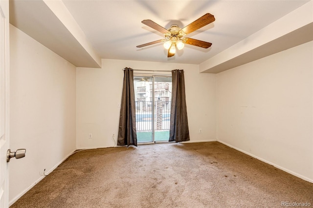 carpeted spare room featuring ceiling fan