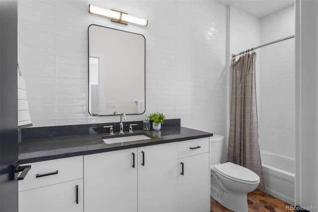bathroom with tile walls, vanity, toilet, and shower / bath combo