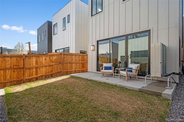 rear view of property with board and batten siding and a patio area
