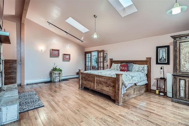bedroom featuring light wood finished floors, a skylight, and baseboards