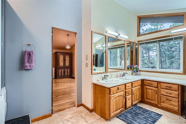 full bath featuring a high ceiling, plenty of natural light, and a sink