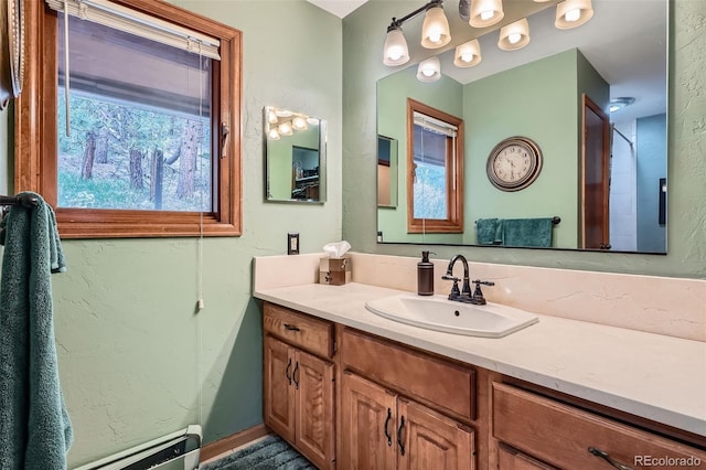 bathroom with a baseboard radiator, vanity, and plenty of natural light