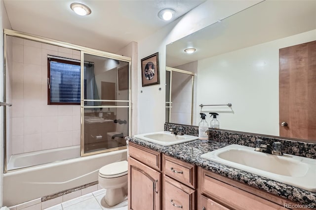 full bathroom featuring double vanity, tile patterned flooring, combined bath / shower with glass door, and a sink