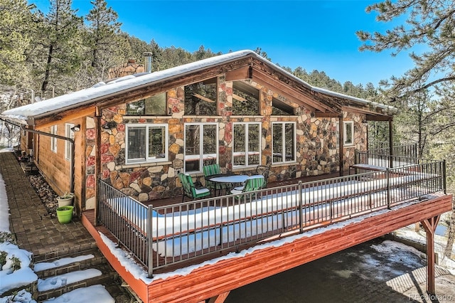 21191 Pleasant Park Rd, Conifer, CO 80433 - snow covered rear of property featuring stone siding and a deck
