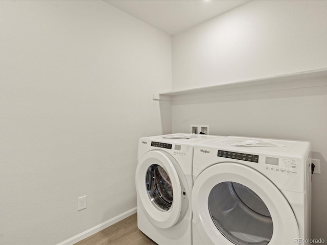 laundry room with light wood-type flooring and washer and clothes dryer