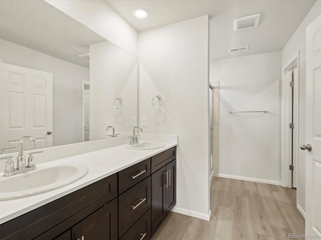 bathroom with vanity, wood-type flooring, and a shower with shower door