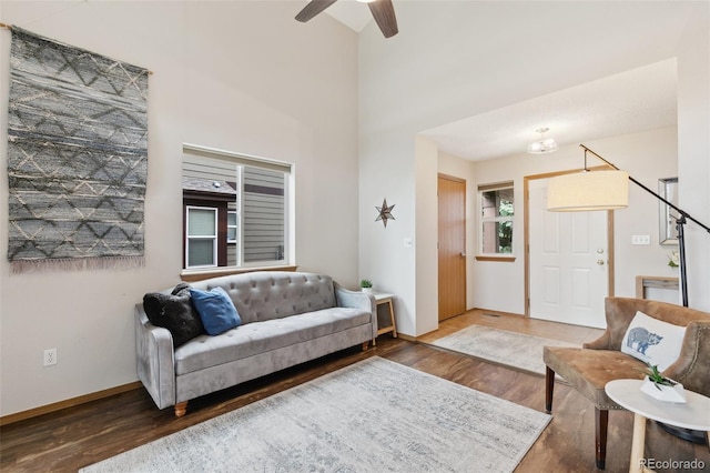 5040 Sweetgrass Ln, Colorado Springs, CO 80922 - living area with wood finished floors, a chandelier, baseboards, a ceiling fan, and a high ceiling
