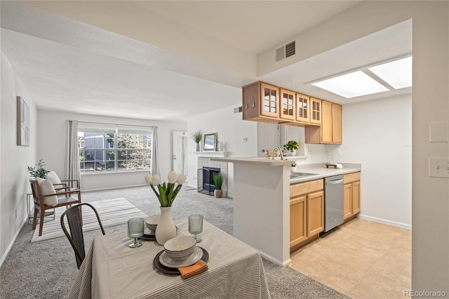 kitchen with dishwasher, a sink, glass insert cabinets, light countertops, and baseboards