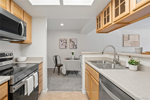 kitchen featuring appliances with stainless steel finishes, a sink, light countertops, light carpet, and recessed lighting