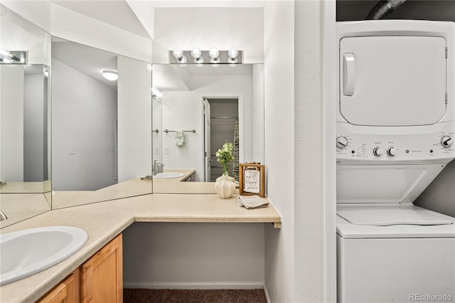 bathroom featuring stacked washing machine and dryer, vanity, and baseboards