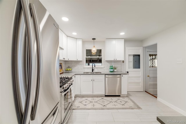2090 Irving St, Denver, CO 80211 - kitchen with stainless steel appliances, a sink, decorative backsplash, white cabinetry, and baseboards