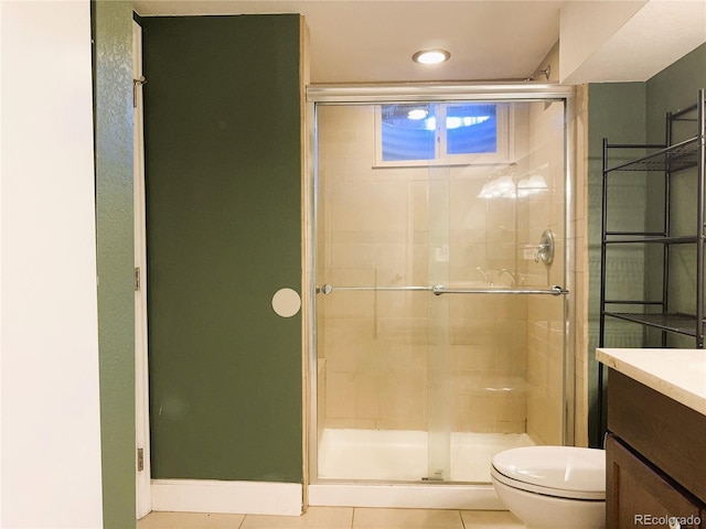 bathroom featuring vanity, tile patterned flooring, a stall shower, and toilet