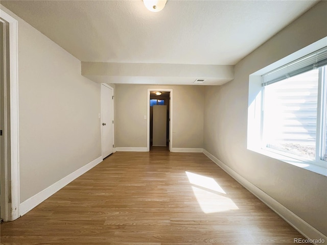 unfurnished bedroom featuring light wood-style floors, baseboards, and visible vents