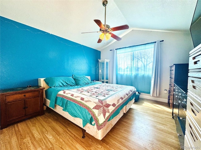 bedroom with baseboards, ceiling fan, vaulted ceiling, and light wood-style flooring