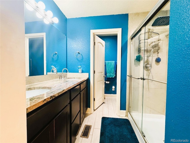 full bath with double vanity, visible vents, a sink, and a stall shower