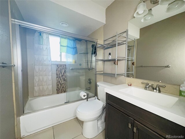 bathroom with vanity, combined bath / shower with glass door, tile patterned flooring, and toilet