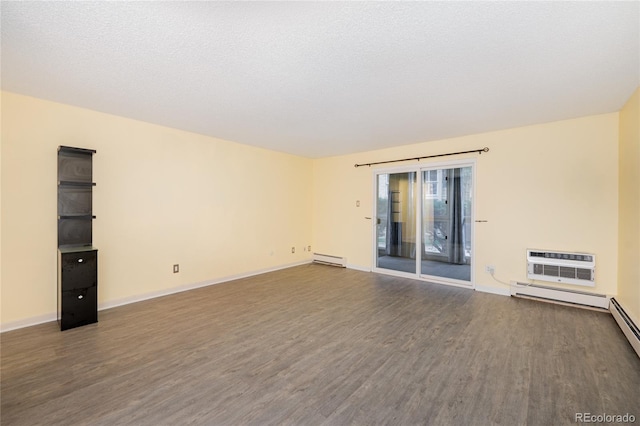 empty room with a textured ceiling, a wall mounted air conditioner, baseboard heating, and wood-type flooring