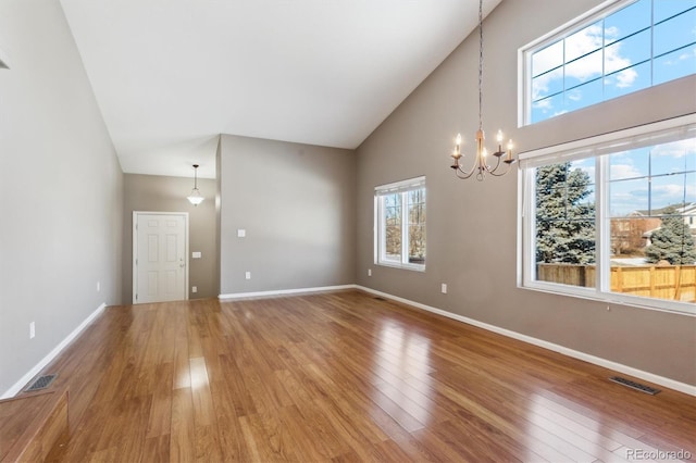 interior space featuring high vaulted ceiling, hardwood / wood-style floors, and a chandelier