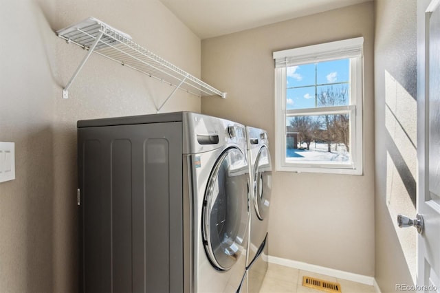 laundry area with washing machine and dryer and light tile patterned flooring