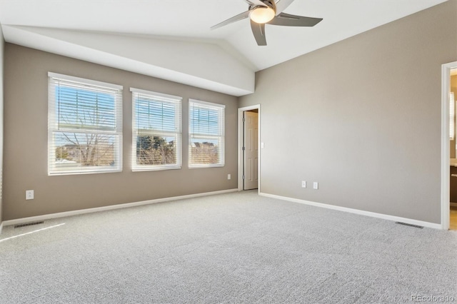 spare room featuring ceiling fan, light colored carpet, and vaulted ceiling