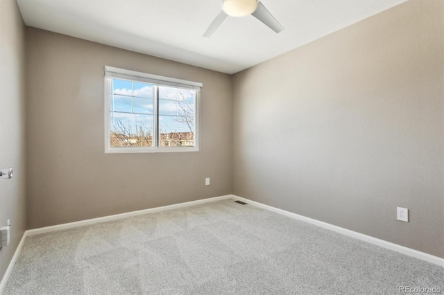 carpeted spare room with ceiling fan