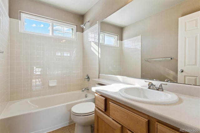 full bathroom featuring vanity, tile patterned floors, toilet, and tiled shower / bath